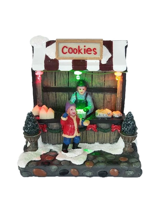 Освещенный магазин рождественского печенья с мальчиком